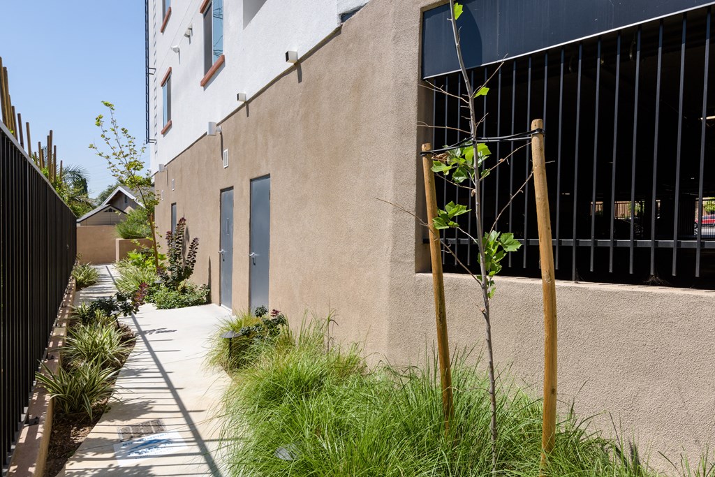 the side of a building with a fence and a sidewalk