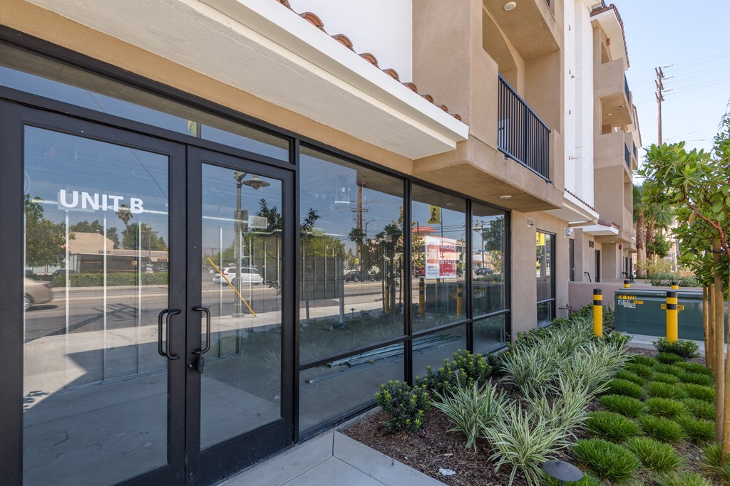 the entrance to a building with glass doors and a sidewalk