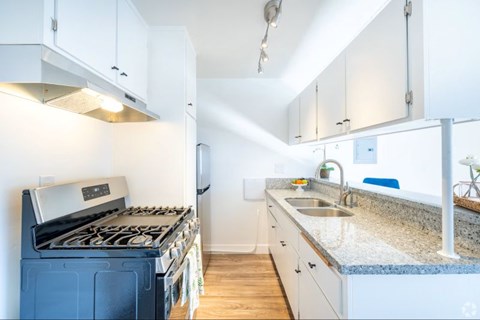 A kitchen with a blue stove and white cabinets.