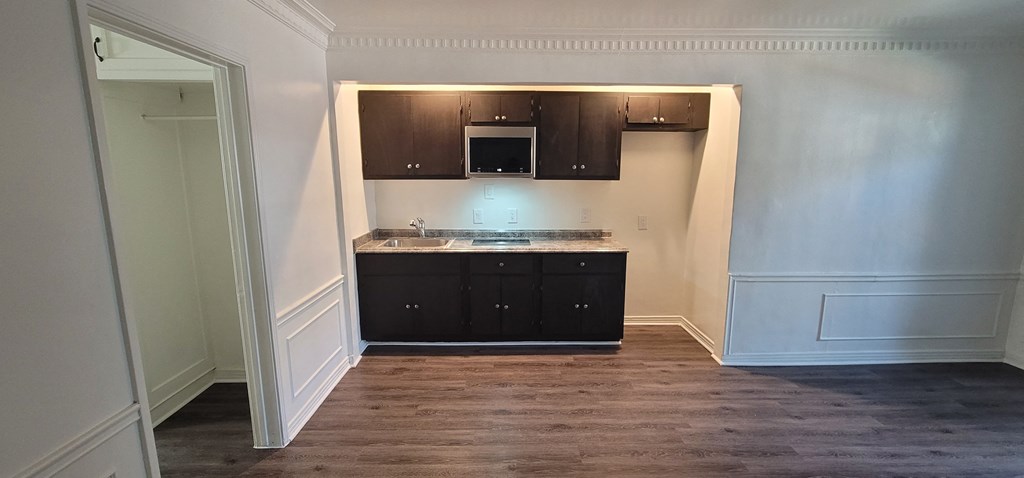 a small kitchen with dark cabinets and a counter