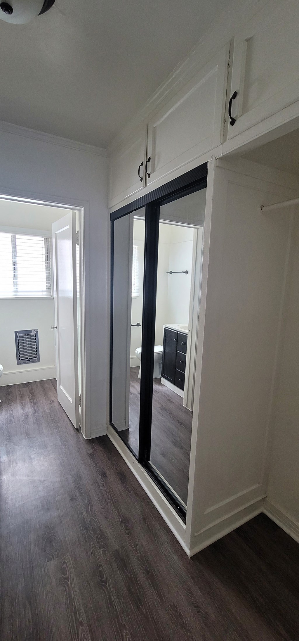 a mirror on the wall in a room with a wood floor