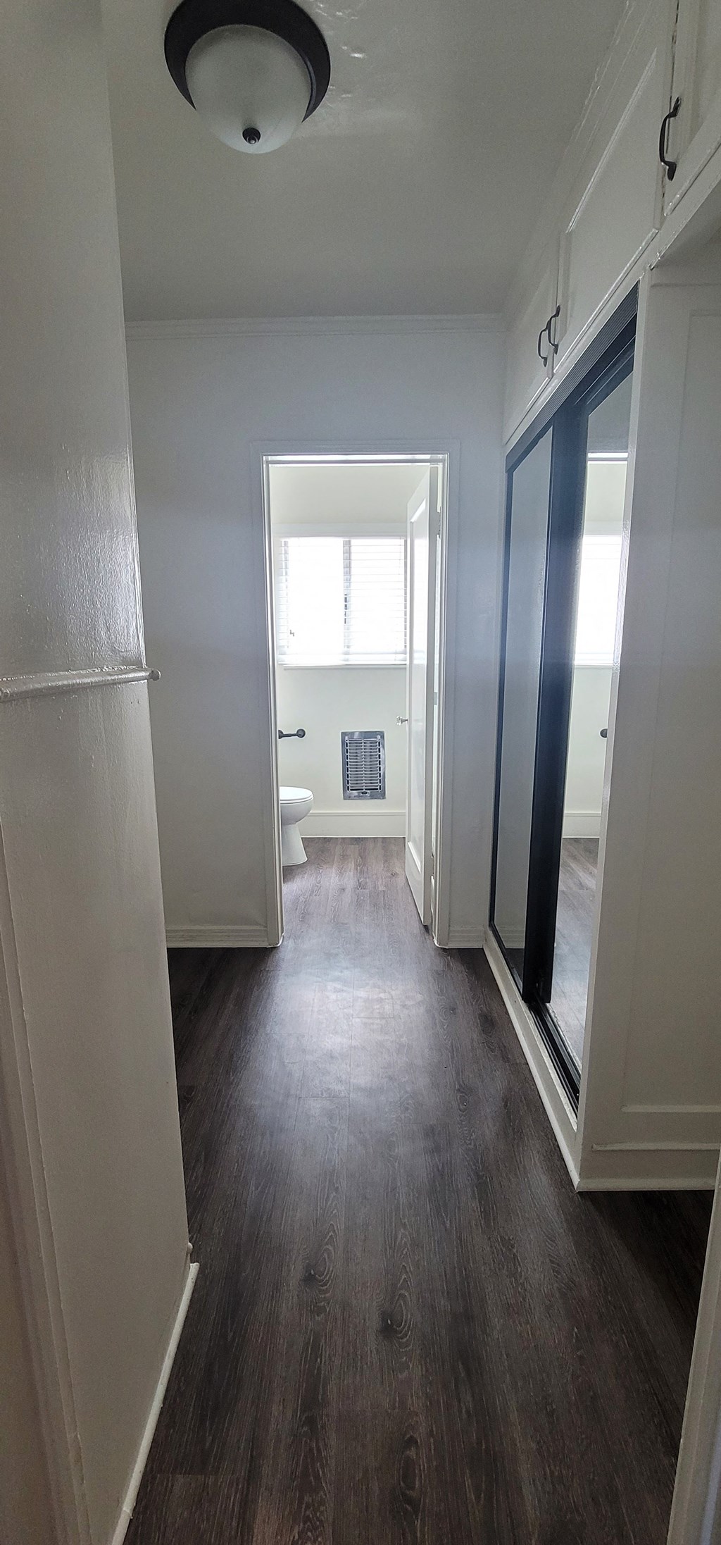 a view of the hallway from the master bedroom into the bathroom with a large mirror