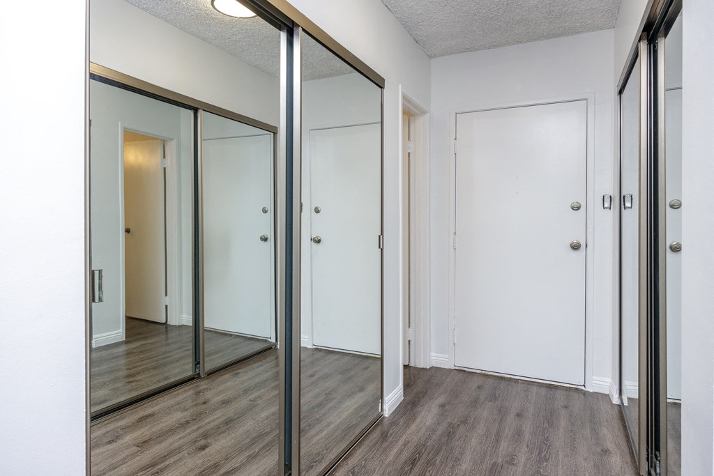 an empty room with mirrors on the wall and a wood floor