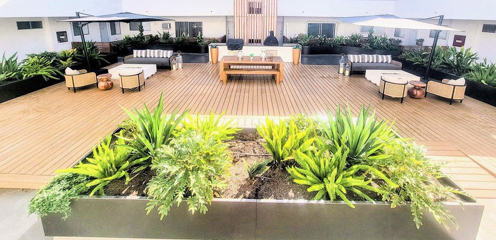 A wooden deck with a planter box in the middle.
