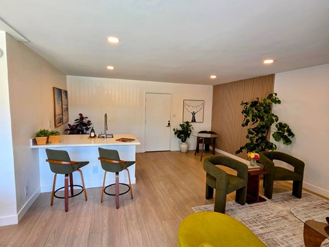 A living room with a bar area and a green chair.