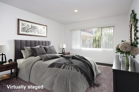 A bedroom with a large bed and a painting on the wall.