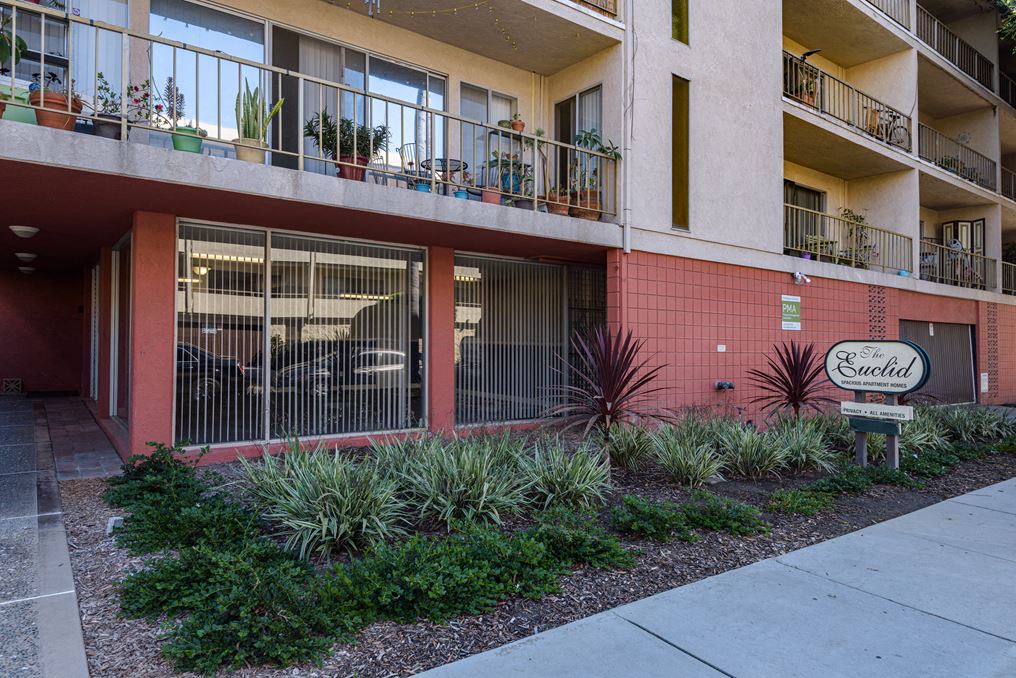an apartment building with a sign in front of it
