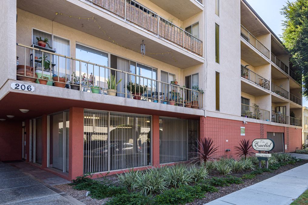 an apartment building with balconies and a sign in front of it