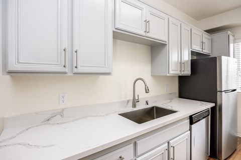 a kitchen with white cabinets and a sink