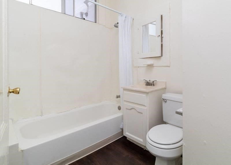 a bathroom with a toilet and a tub and a sink