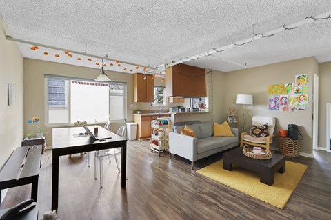 A living room with a couch, coffee table, and a dining table.