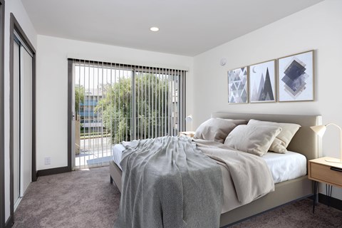 a bedroom with a bed and a sliding glass door