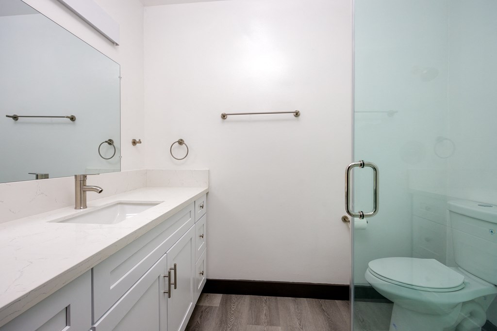 a white bathroom with a toilet and a sink
