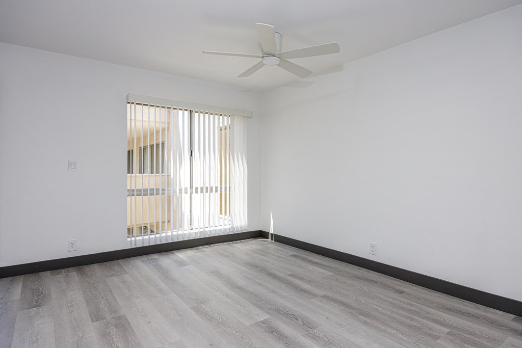 an empty room with white walls and a ceiling fan