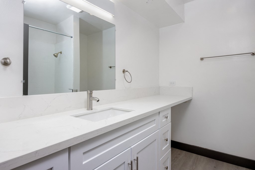 an empty bathroom with a sink and a mirror