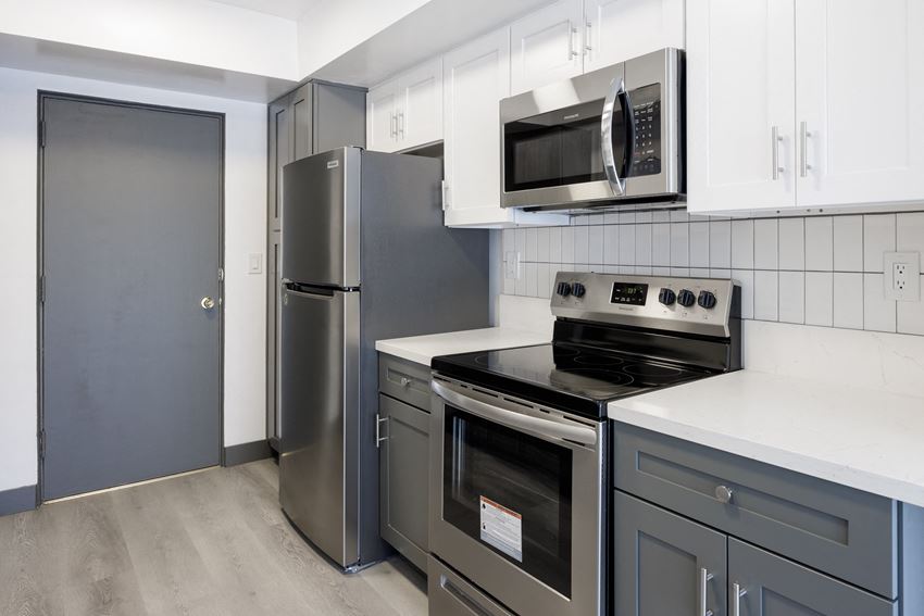 a kitchen with gray and white cabinets and stainless steel appliances - Photo Gallery