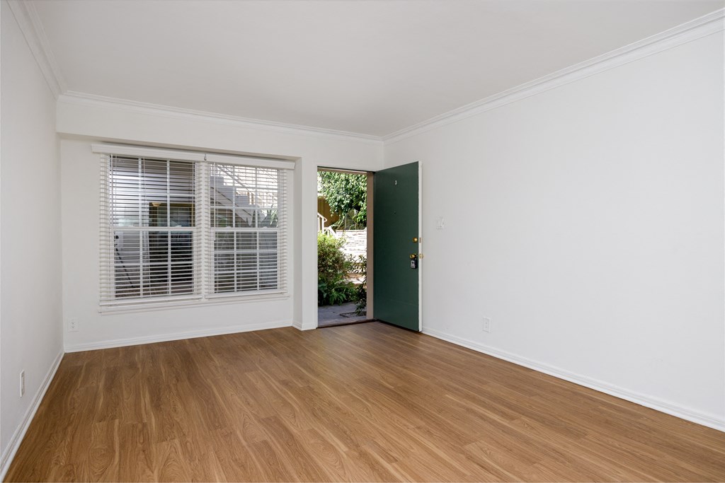 a bedroom with hardwood floors and white walls