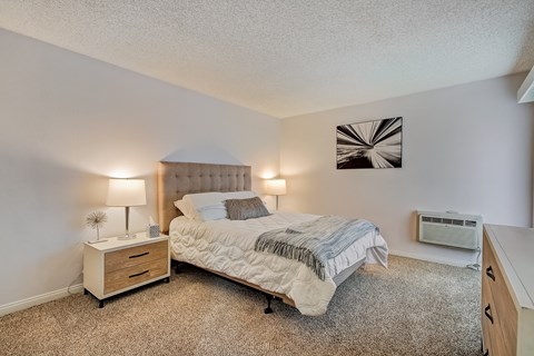 a bedroom with a bed and a dresser with a nightstand