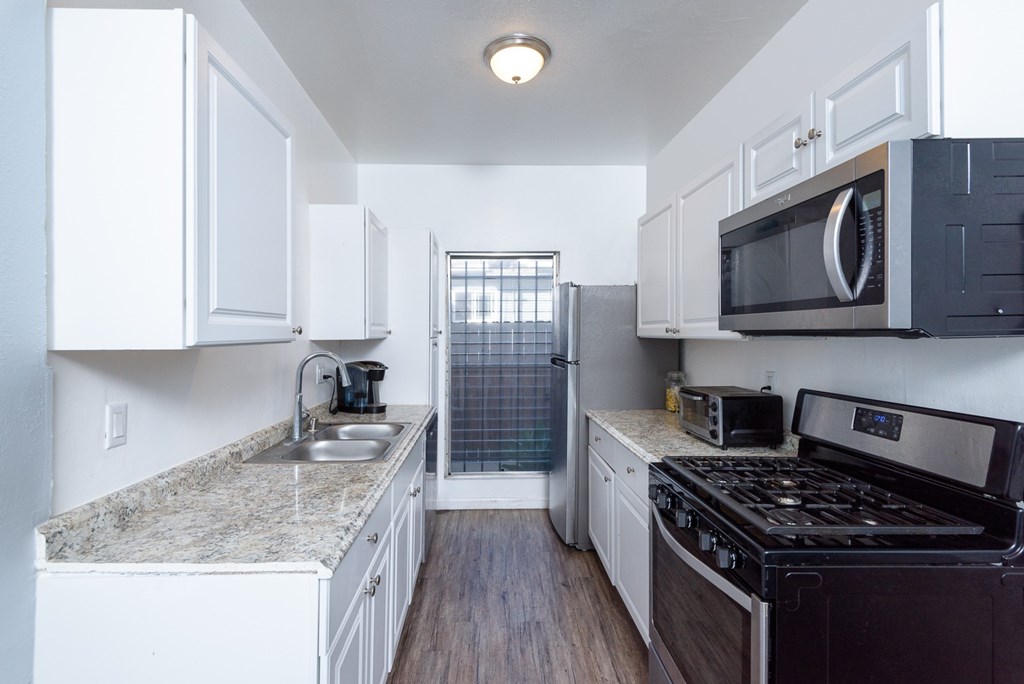 A kitchen with white cabinets and a black stove top oven.