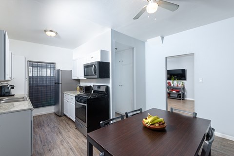 A kitchen with a table and chairs in the foreground.