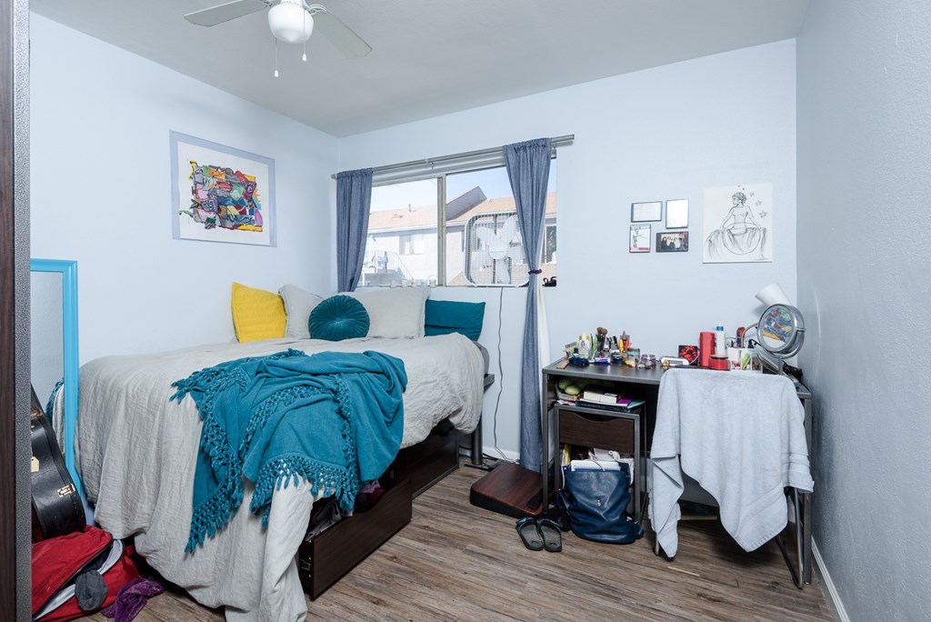 A bedroom with a bed, desk, and chair.