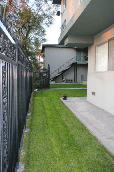 a yard with a fence and a house with a staircase