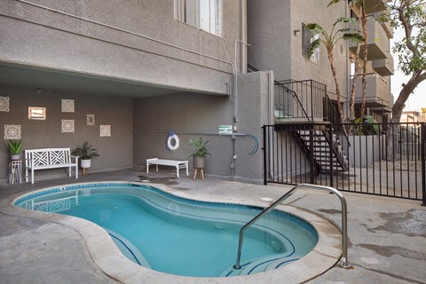 A small pool in a courtyard surrounded by a fence.