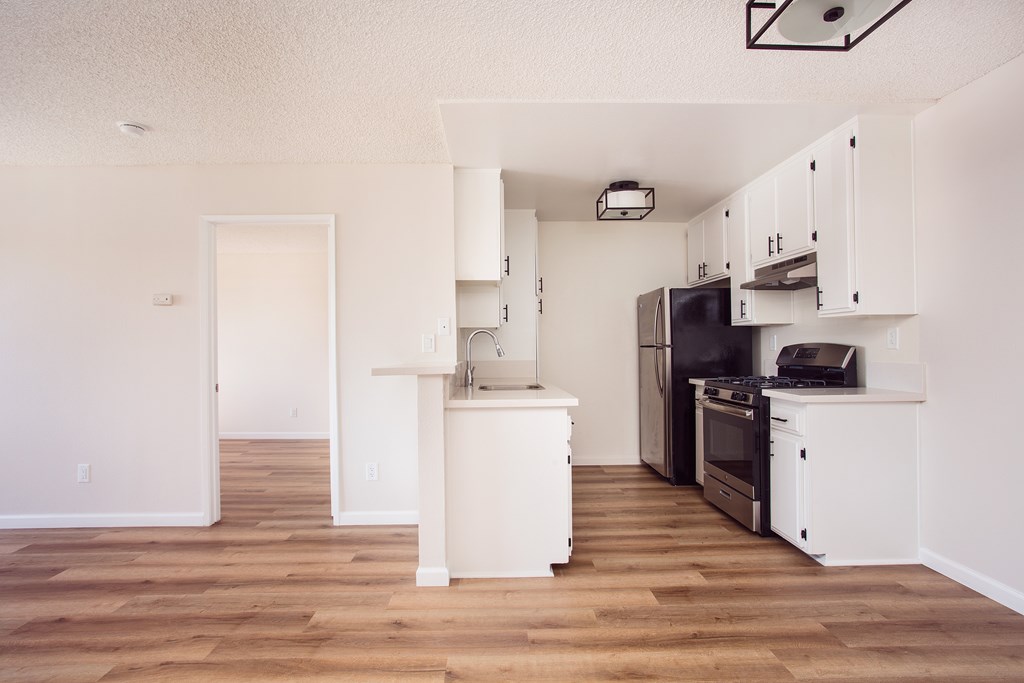 A kitchen with white cabinets and appliances.