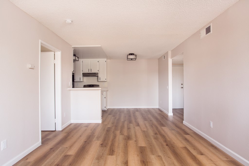 A kitchen area with a white counter and cabinets.