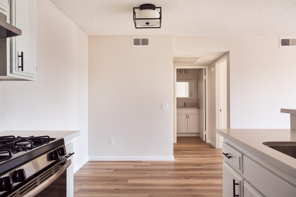 A kitchen with a stove top oven and a sink.