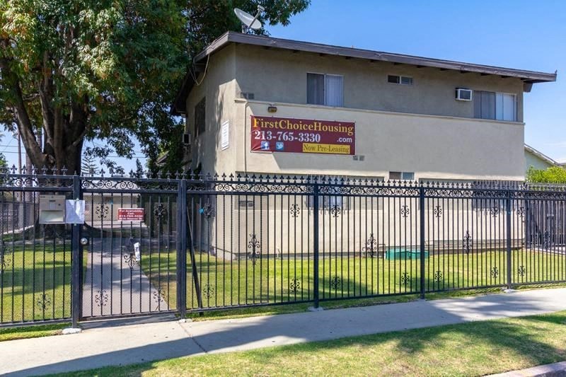 a building with a fence and a sign on the side of it