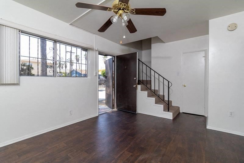 a living room with a staircase and a ceiling fan