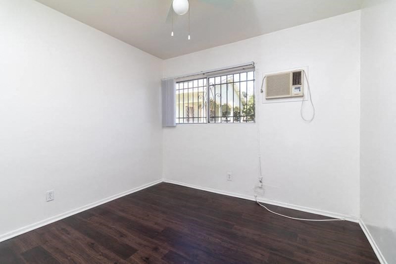 an empty room with white walls and a window and a air conditioner