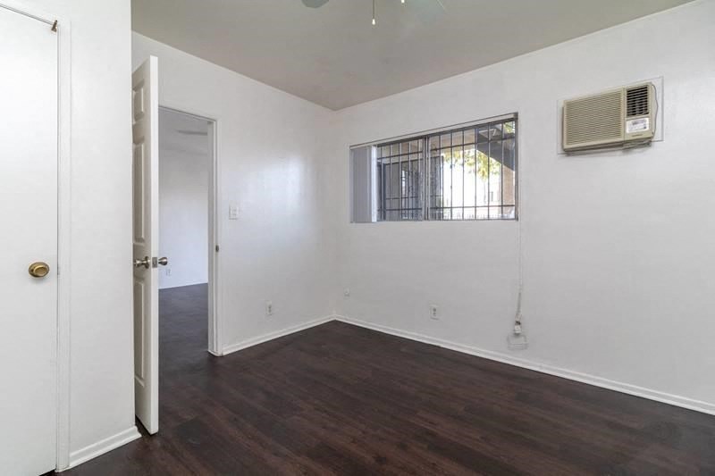 an empty room with white walls and a window and a air conditioner
