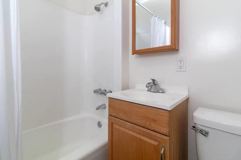 an empty bathroom with a sink toilet and shower