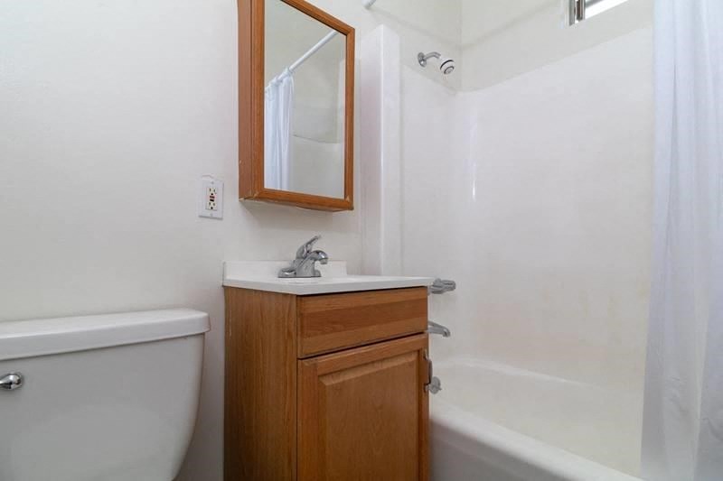 a bathroom with a toilet and a sink and a mirror