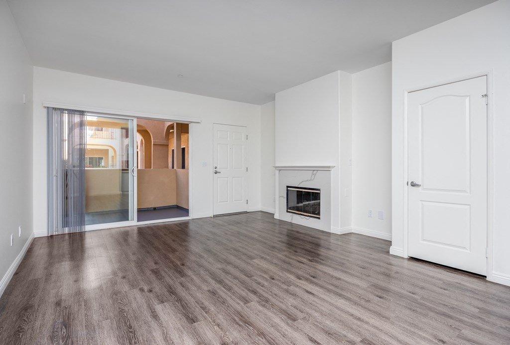 a bedroom with hardwood floors and white walls