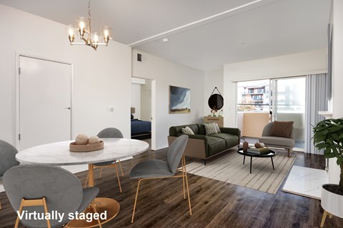 A modern living room with a white table and grey chairs.