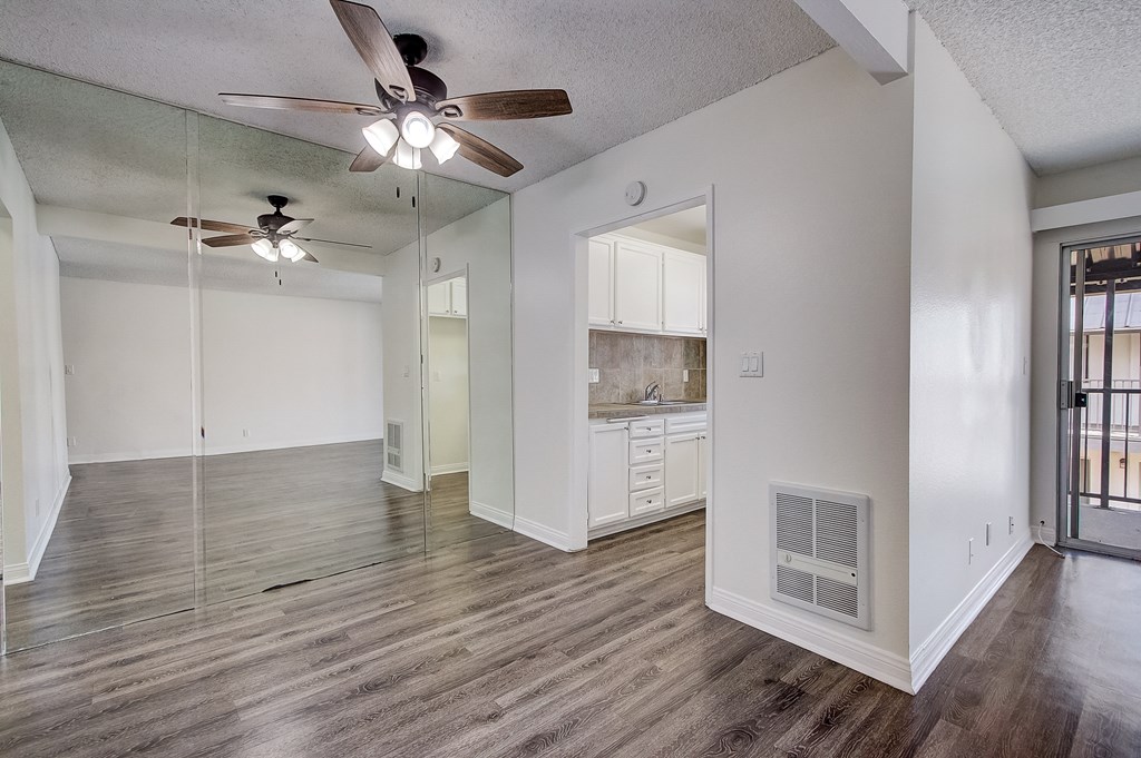 an empty living room with a ceiling fan