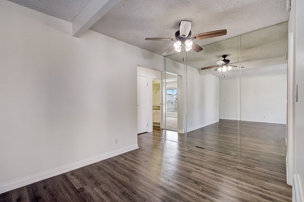 an empty living room with a ceiling fan