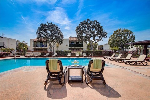 a swimming pool with lounge chairs and a coffee table