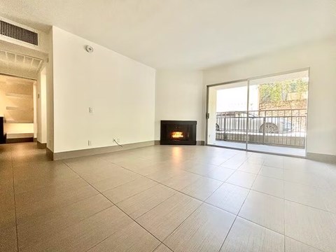 A spacious living room with a fireplace and sliding glass doors.