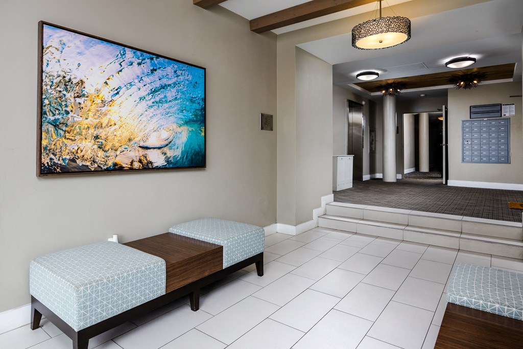 a lobby with a painting on the wall and benches