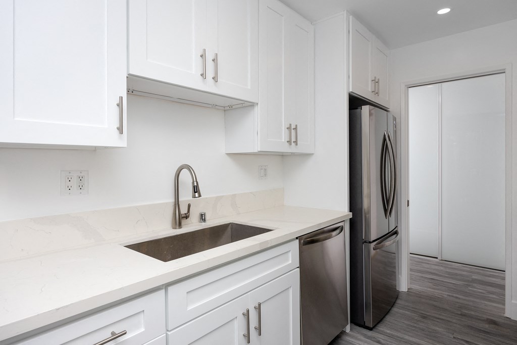 a kitchen with white cabinets and a sink