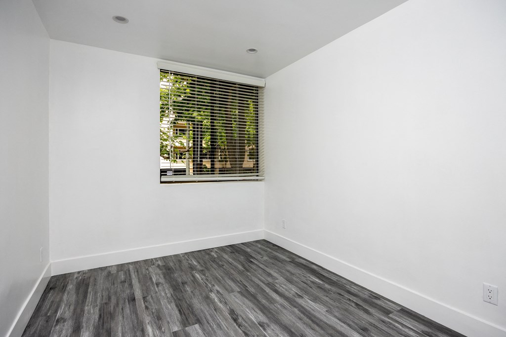 an empty room with white walls and a window