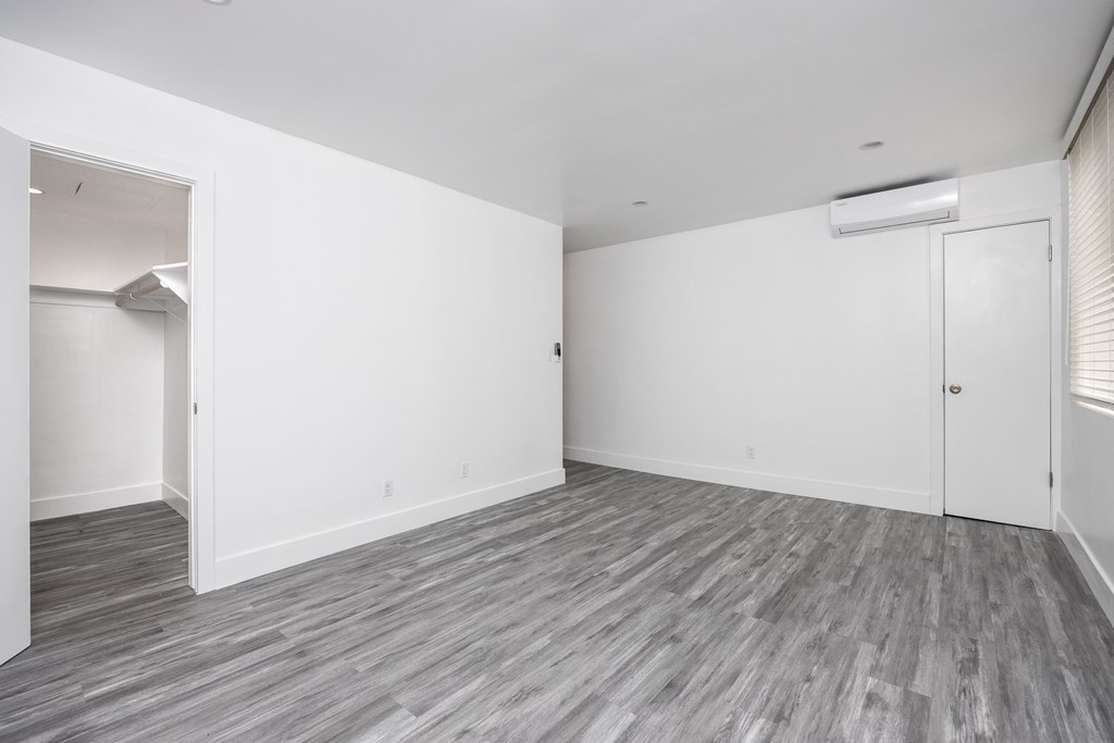 an empty living room with white walls and wood flooring