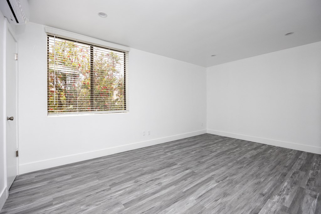 an empty room with white walls and a window