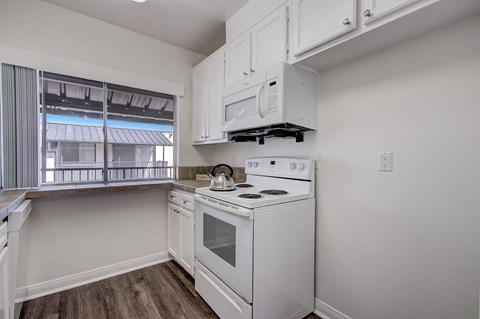 a kitchen with white appliances and white cabinets