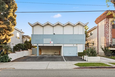 A modern building with a unique design is located on a street.