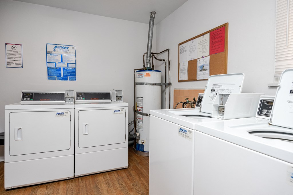 a laundry room with two washers and two washing machines